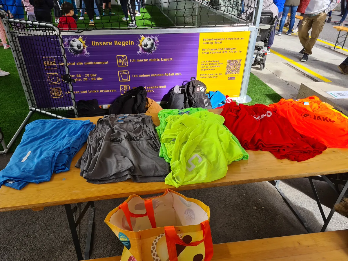 Mehrere Trikots liegen auf einem Holztisch.